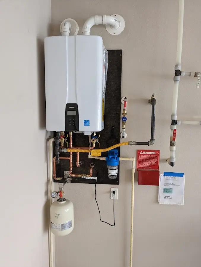Professional plumber installing copper piping in a Buda home